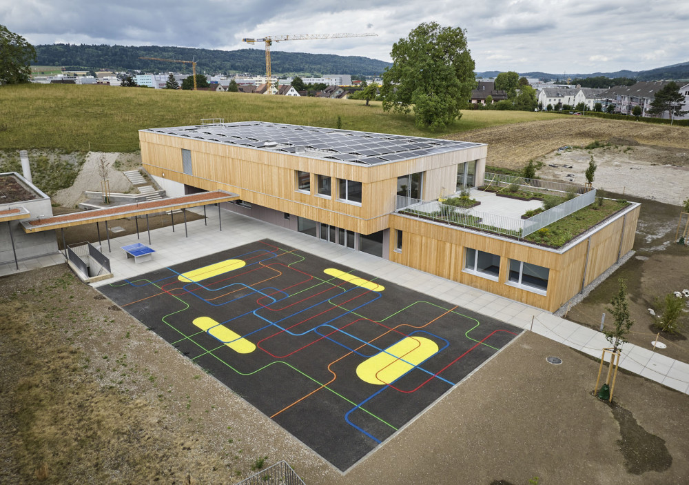 Drohnenansicht des Kindergartens mit Aussicht auf Photovoltaikanlage sowie Aussenterrasse